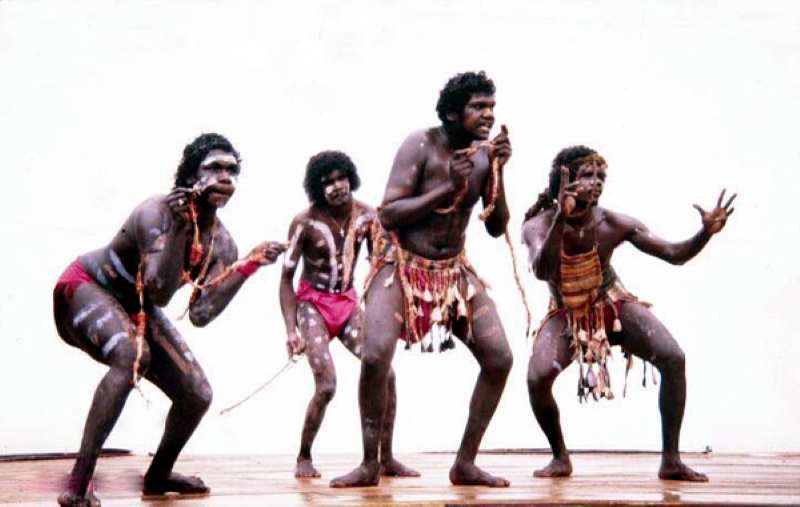 аборигены, танцующие на сцене в набедренных повязках традиционной конструкции