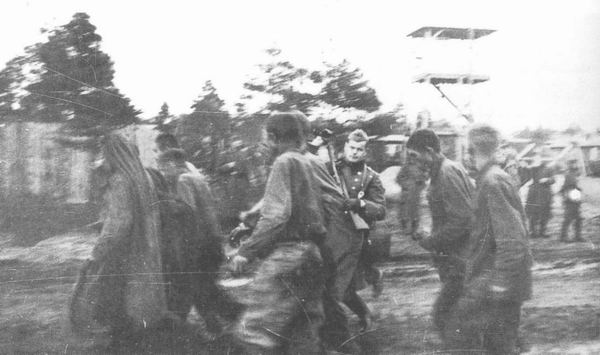 Немецкий охранник подгоняет советских военнопленных в Шталаге ХД