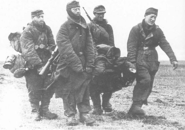 Немецкие солдаты выносят раненого с поля боя под Днепропетровском, 1944 г