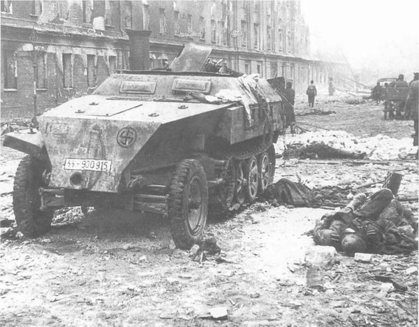 Погибшие солдаты и подбитый бронетранспортер одной из частей войск СС в Берлине, май 1945 г.