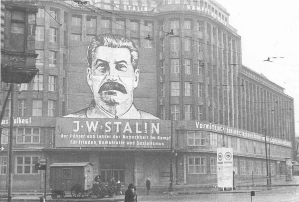 Транспарант с портретом Сталина и лозунгами на здании Центрального Комитета СЕПГ, Берлин, 1950 г.
							(«Сталин - вождь и учитель человечества в борьбе за мир, демократию и социализм».)